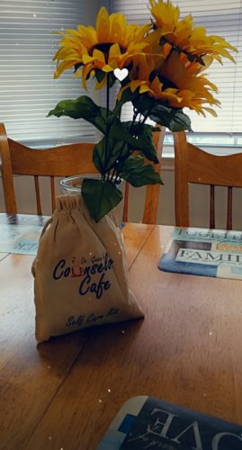 Picture of Self-Care Kit sitting on a kitchen table with sunflowers.